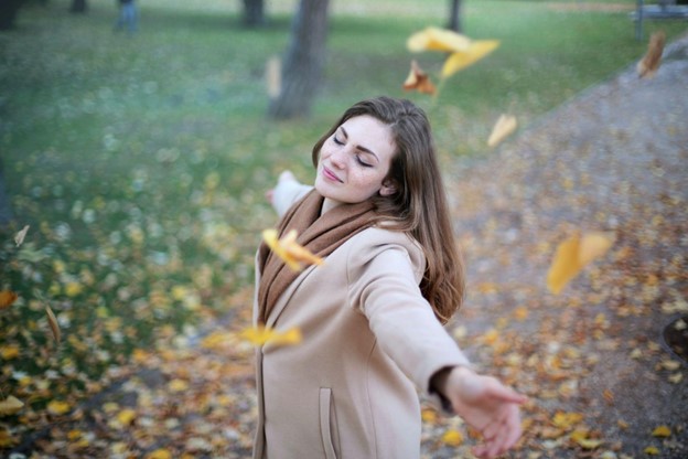 a happy smiling woman thinking about spreading love and kindness