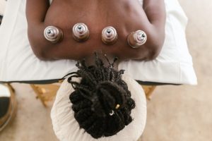 Woman laying on the bed with suction placed on her upper back