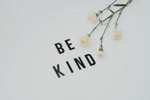 “be kind” on a white surface with flowers, a way of spreading kindness