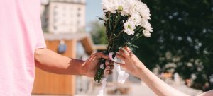 : a man giving flowers to a woman