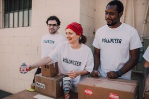 Three volunteers handing out food