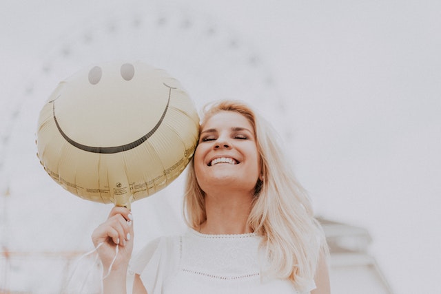 A happy woman after learning about overcoming loneliness when you're new in town.