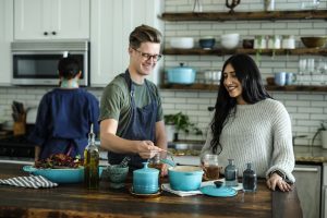 A man and a woman socializing during a cooking class.