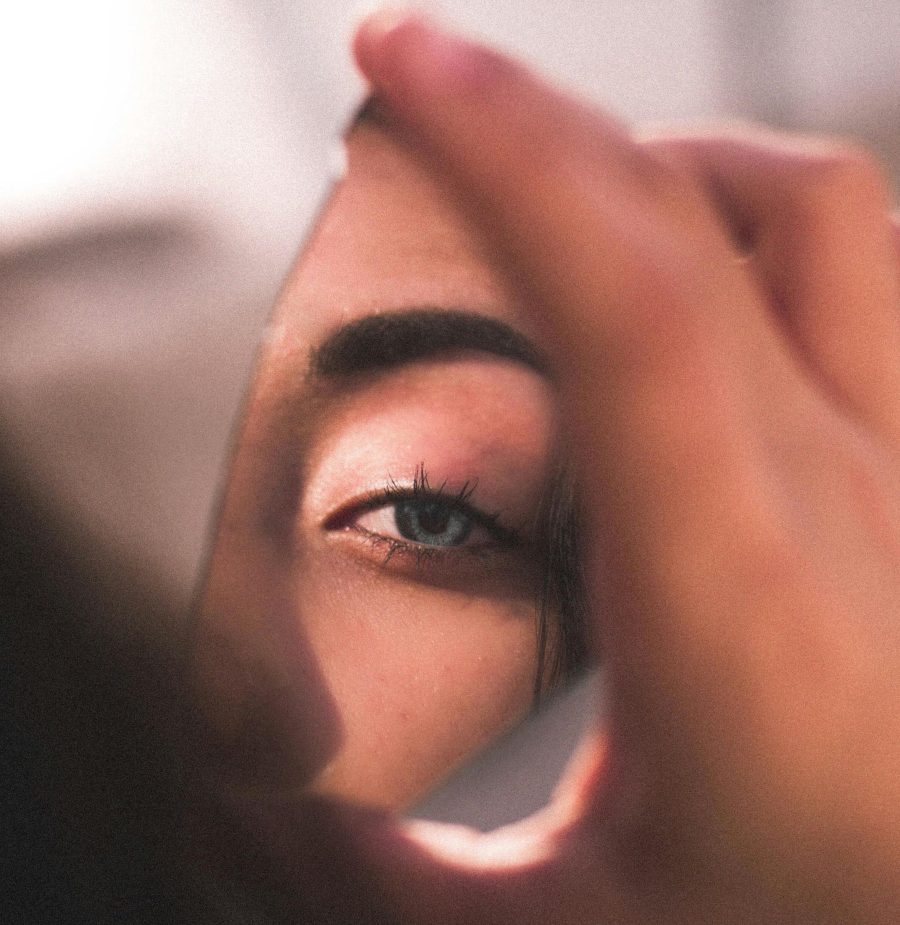 Reflection of a woman in a broken mirror.